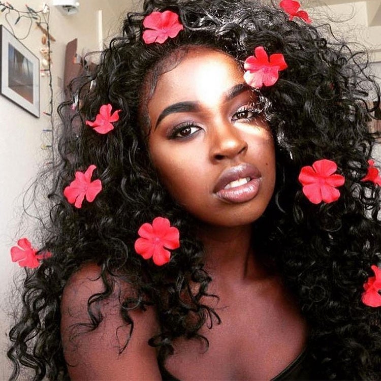 Woman with red flower petals in her hair.